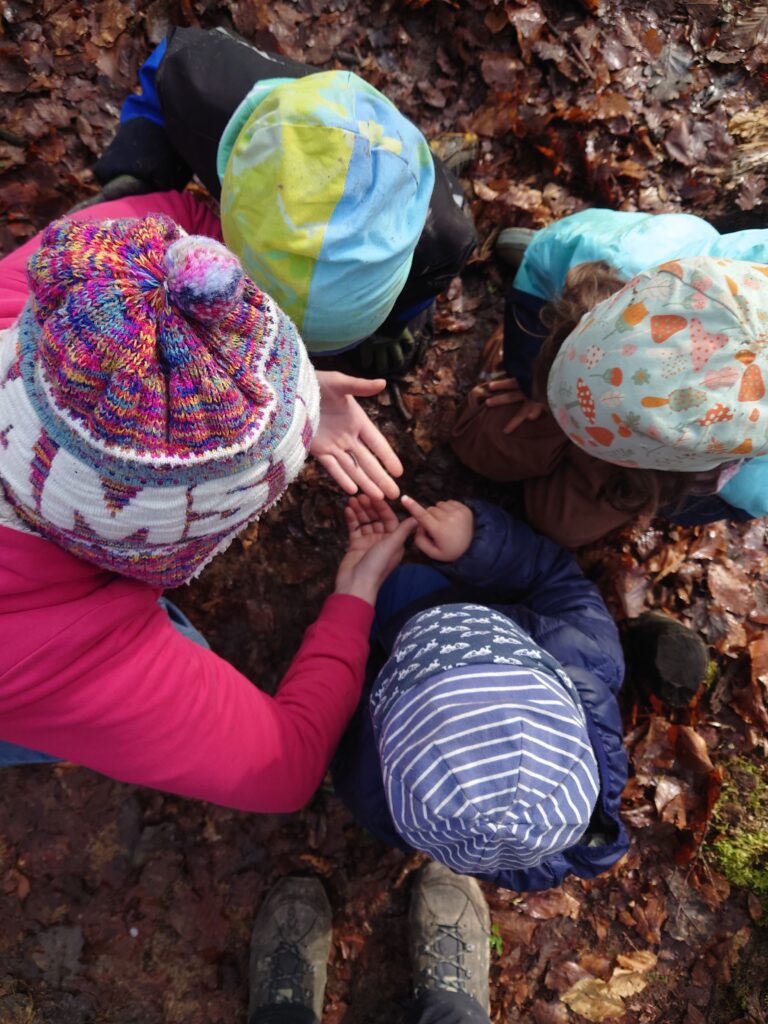 Kinder sitzen gemeinsam auf dem Waldboden