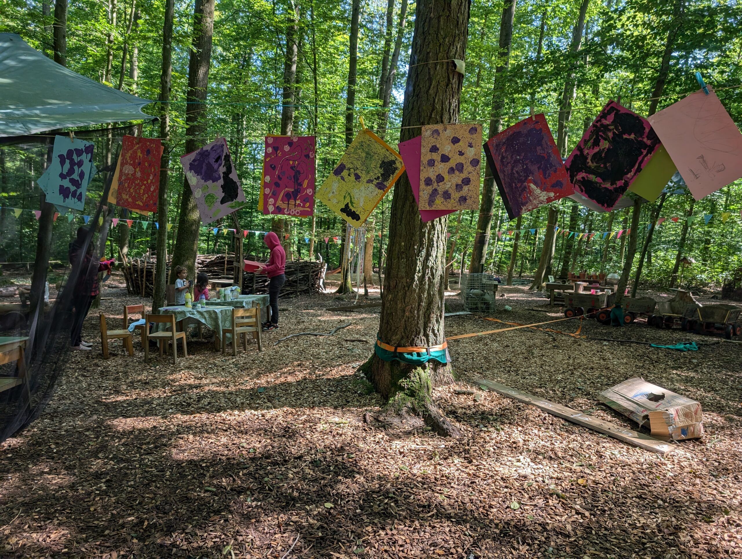 Waldplatz des Waldkindergartens mit bunter Wimpelkette